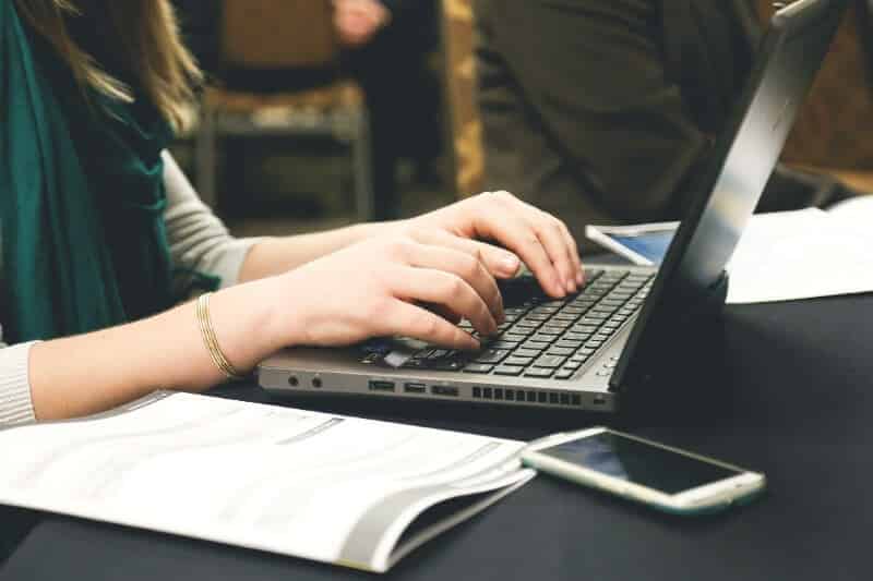 Mujer escribiendo en una laptop/ ciberseguridad