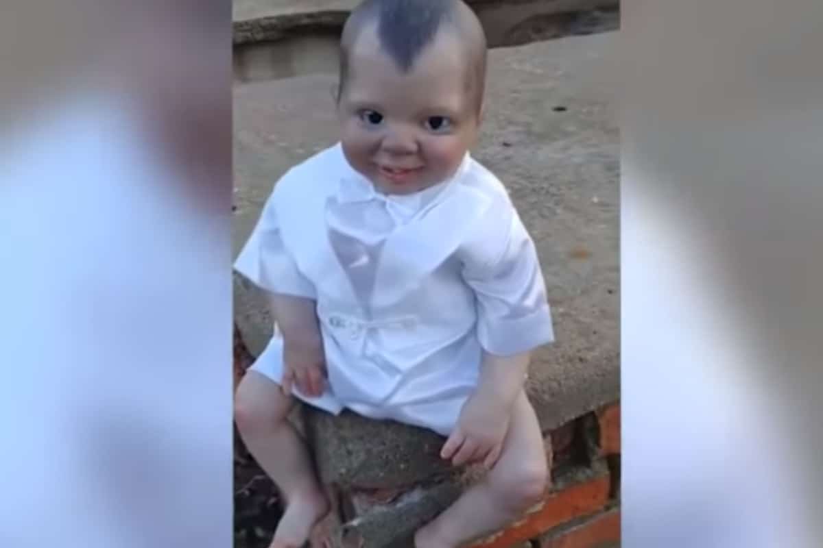 En la grabación se observa al "muñeco" vestido con un traje blanco similar a la ropa de bautizo de la religión católica, mientras está sentado sobre lo que parece ser una tumba