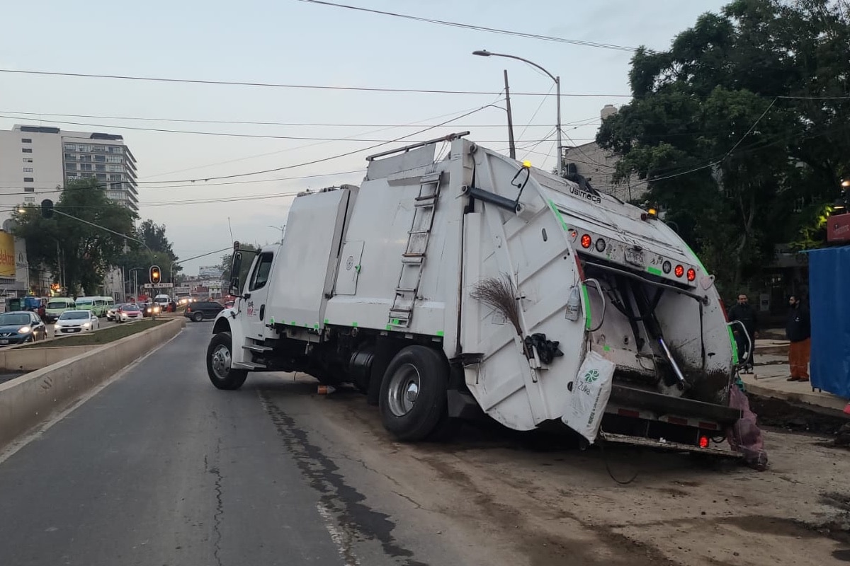 Camión se queda atorado en socavón