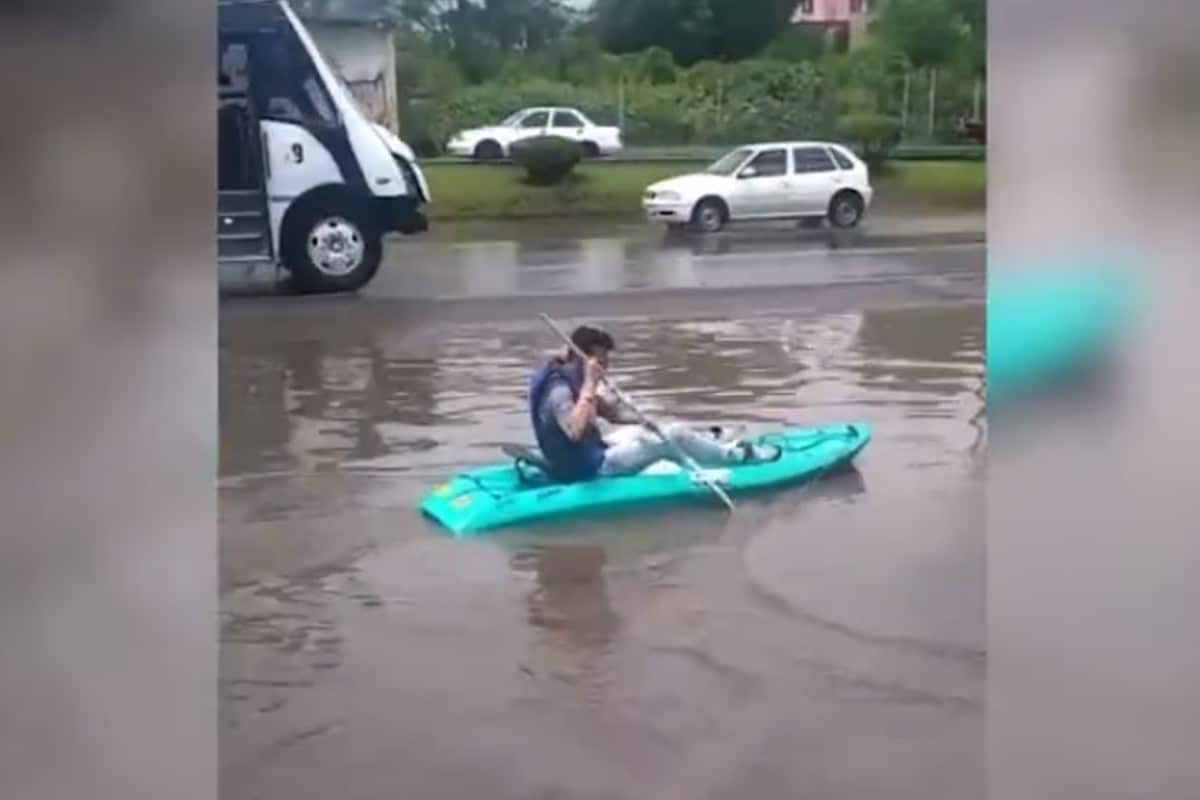 Al fondo de la escena, se contempla el paso de varios camiones y motociclistas que costado a un lado del kayak