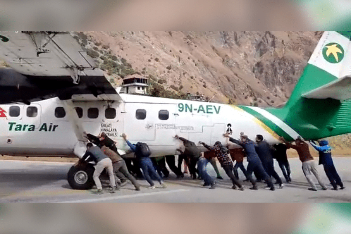 Foto: Captura de video. Twitter@PLA_samrat | Oficiales y pasajeros empujar aeroplano para sacarlo de la pista de aterrizaje