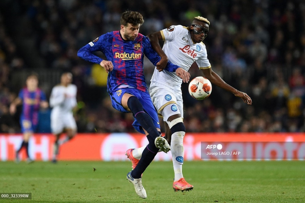 Gerard Pique diputando el balón con el delantero Victor Osimhen.