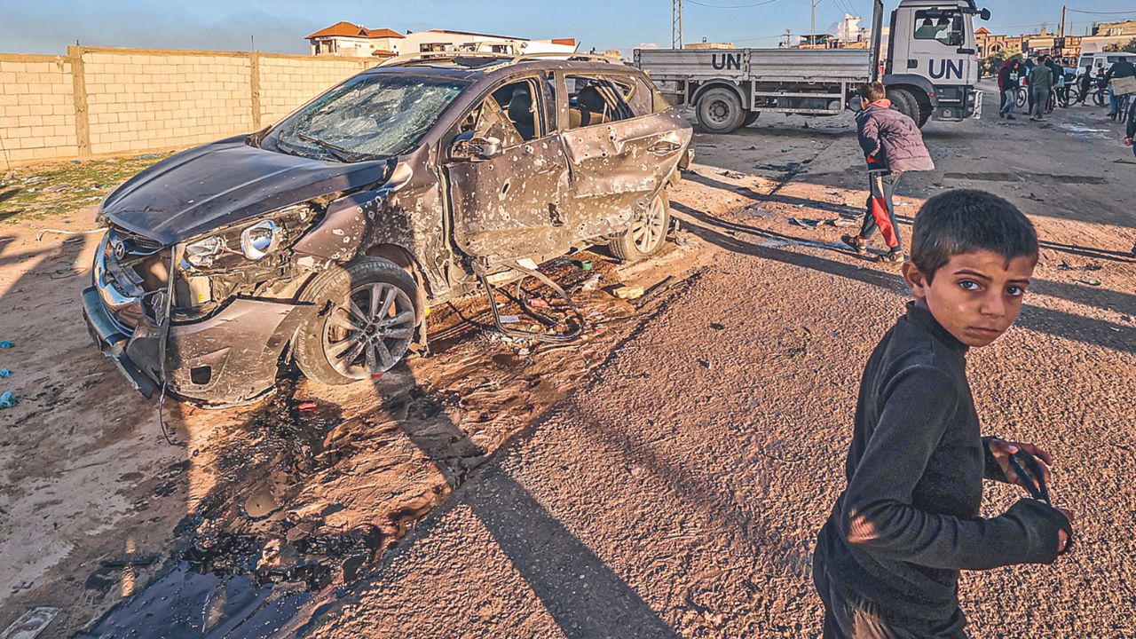 BOMBARDEO. Unos niños caminaban ayer cerca de un coche dañado en el que murieron varias personas por un ataque israelí en Rafah, al sur de la Franja, en medio de la guerra de Israel contra Hamás.