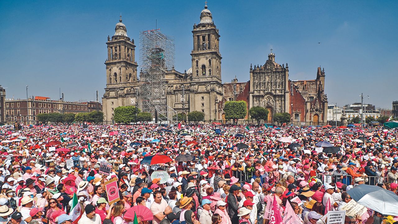 Son las 9:00 horas en el Zócalo capitalino, donde poco a poco comienzan a aparecer, a solas y en grupos, personas vestidas de rosa