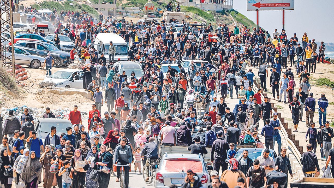 RETORNO. Habitantes palestinos desplazados tomaron ayer la carretera costera de Rashid para regresar a sus casas, a su paso por Nuseirat, en el centro de la Franja, en medio del actual conflicto entre Israel y el movimiento islamista Hamás.