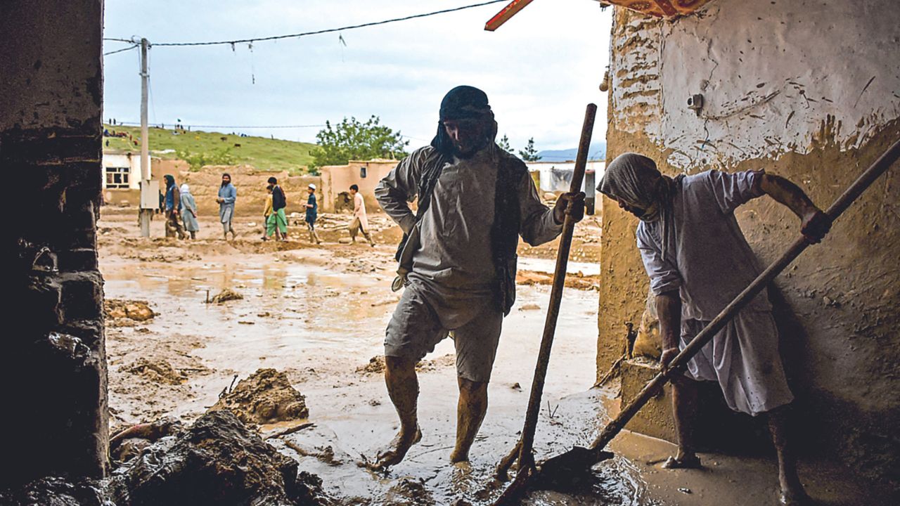 TRAGEDIA. Mientras hombres afganos sacaban ayer el barro de una casa en la provincia de Baghlan, una carretera fue dañada por las repentinas lluvias y el flujo de lava fría de un volcán en Tanah Datar, Sumatra Occidental.