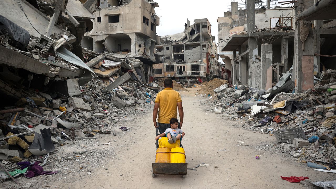 GUERRA. Un palestino caminaba ayer por una carretera rodeada de edificios destruidos en Jan Yunis, en medio de los combates entre Israel y Hamás.