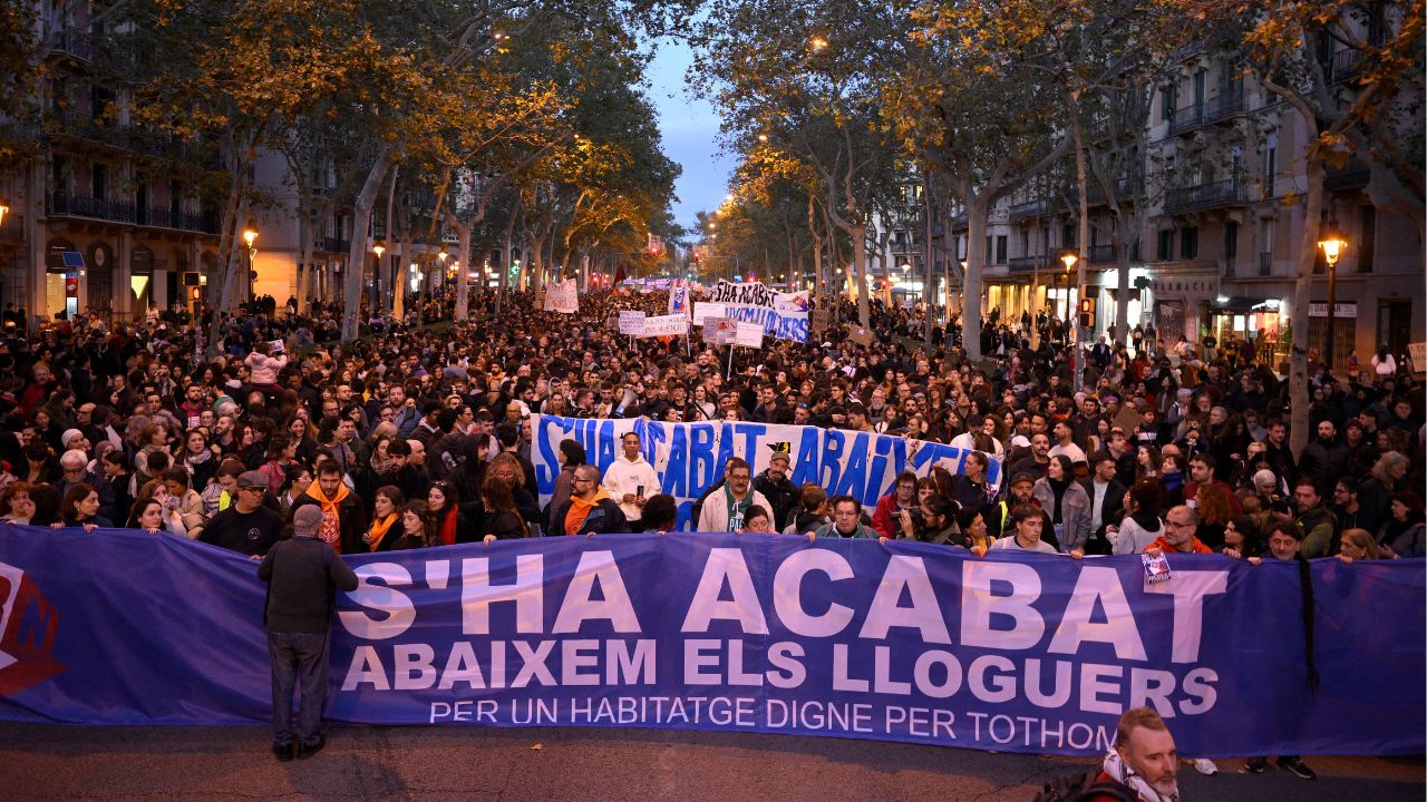 Manifestantes sostienen una pancarta que dice 'Vivienda para todos'