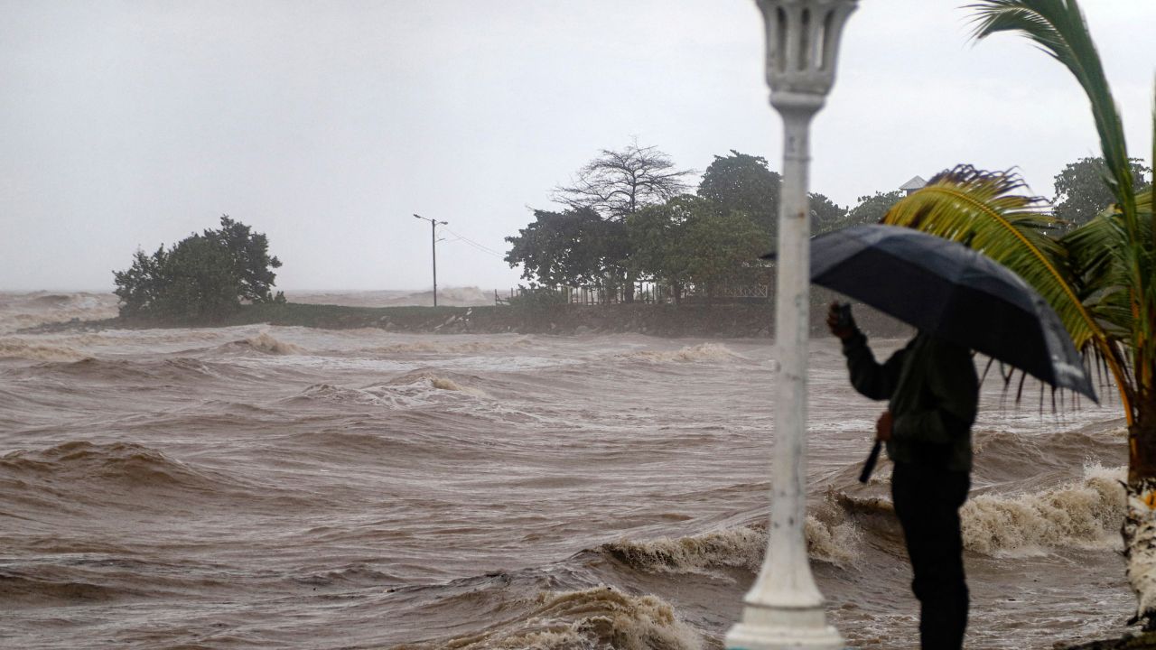 Una persona toma fotografías en el malecón durante el paso de la tormenta tropical Sara en La Ceiba, Honduras.