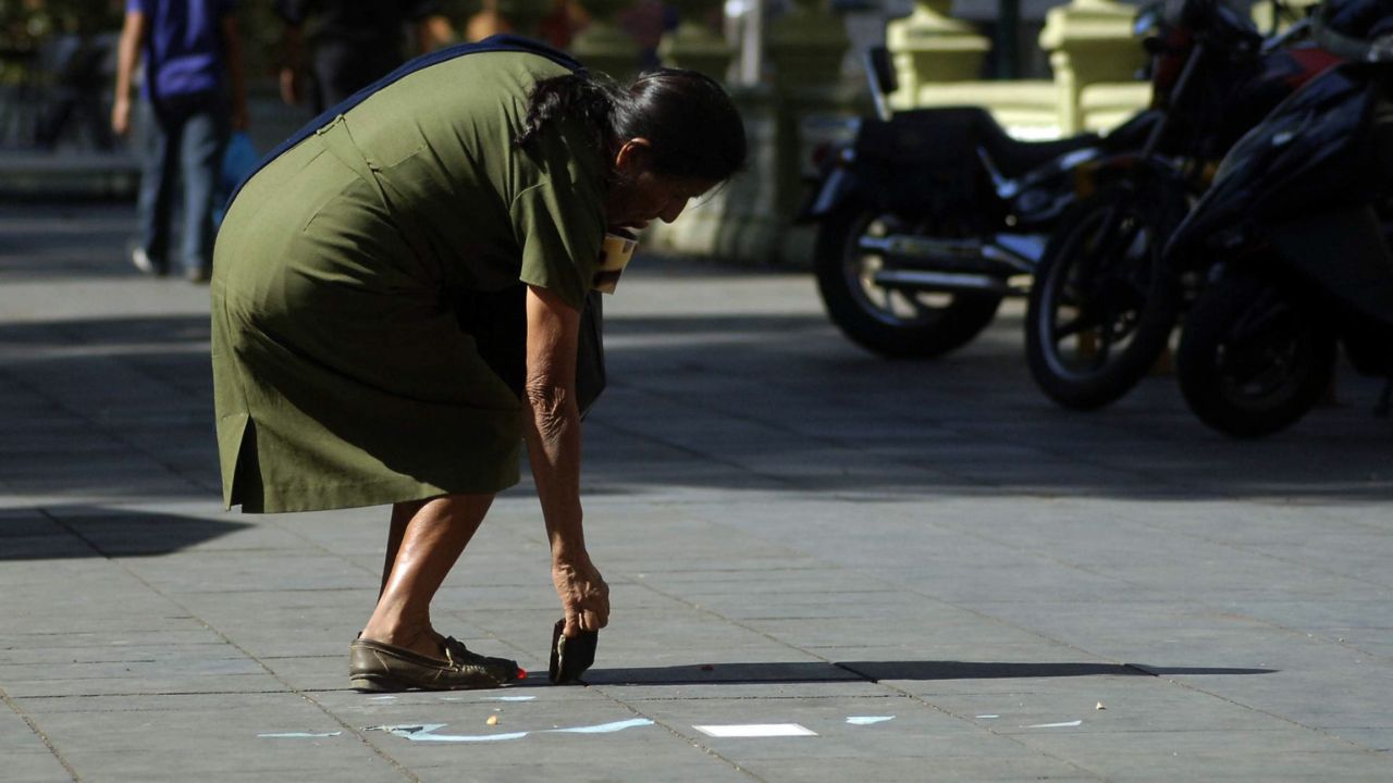 Una señora en la calle es víctima de una broma en el Día de los Santos Inocentes.