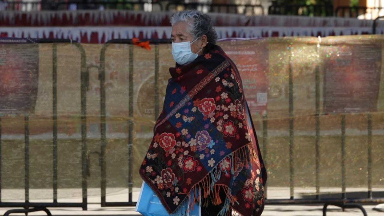 Ante el pronóstico del clima, las personas con cubrebocas y jorongos, se cubren del frío