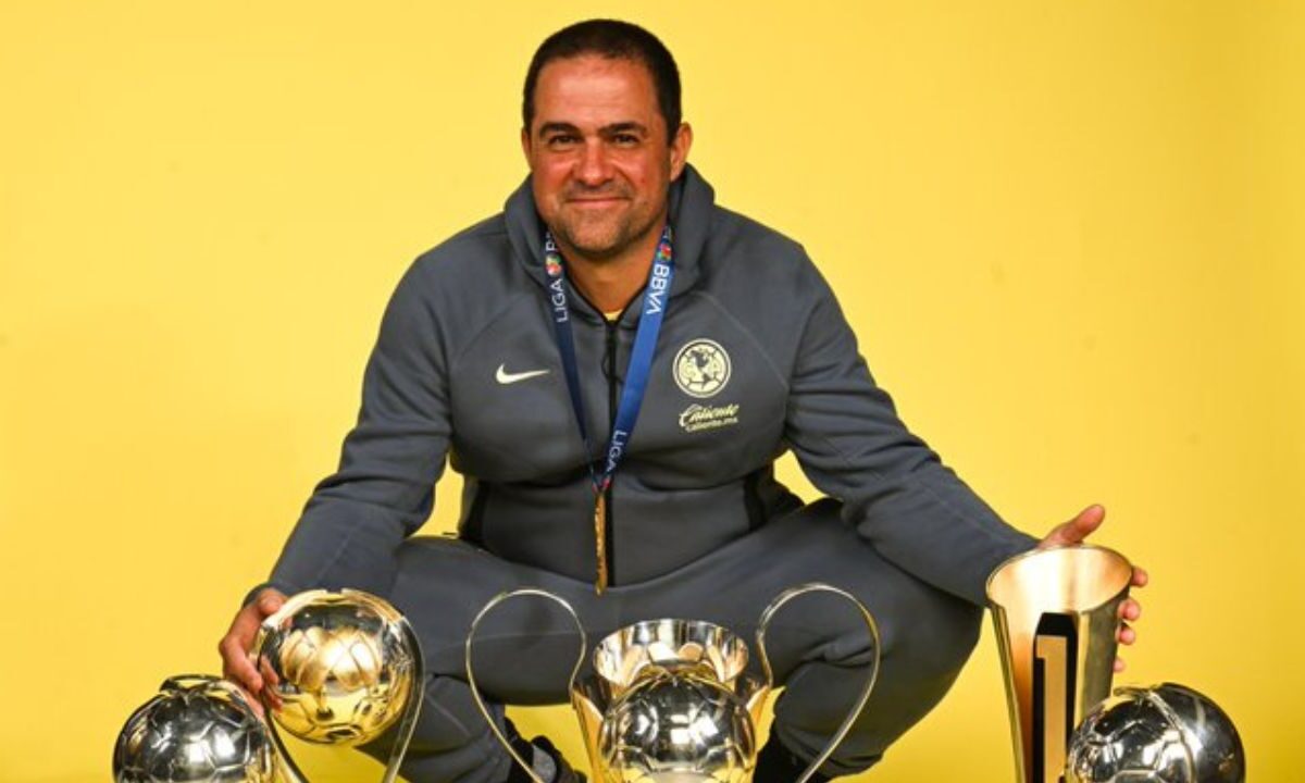 André Jardine, técnico del América, posando junto a los trofeos obtenidos en su gestión.