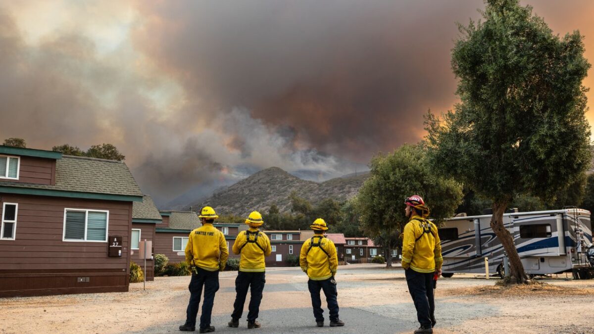 Los bomberos observan cómo el incendio fronterizo arde en el desierto de la montaña Otay