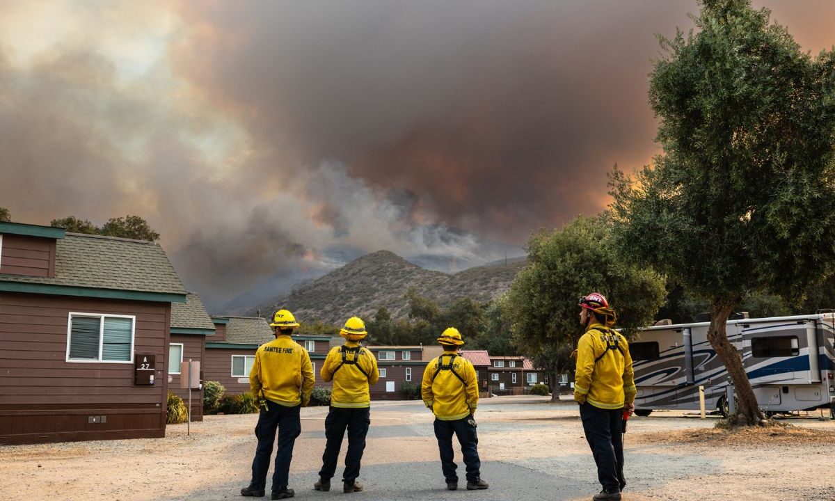 Los bomberos observan cómo el incendio fronterizo arde en el desierto de la montaña Otay