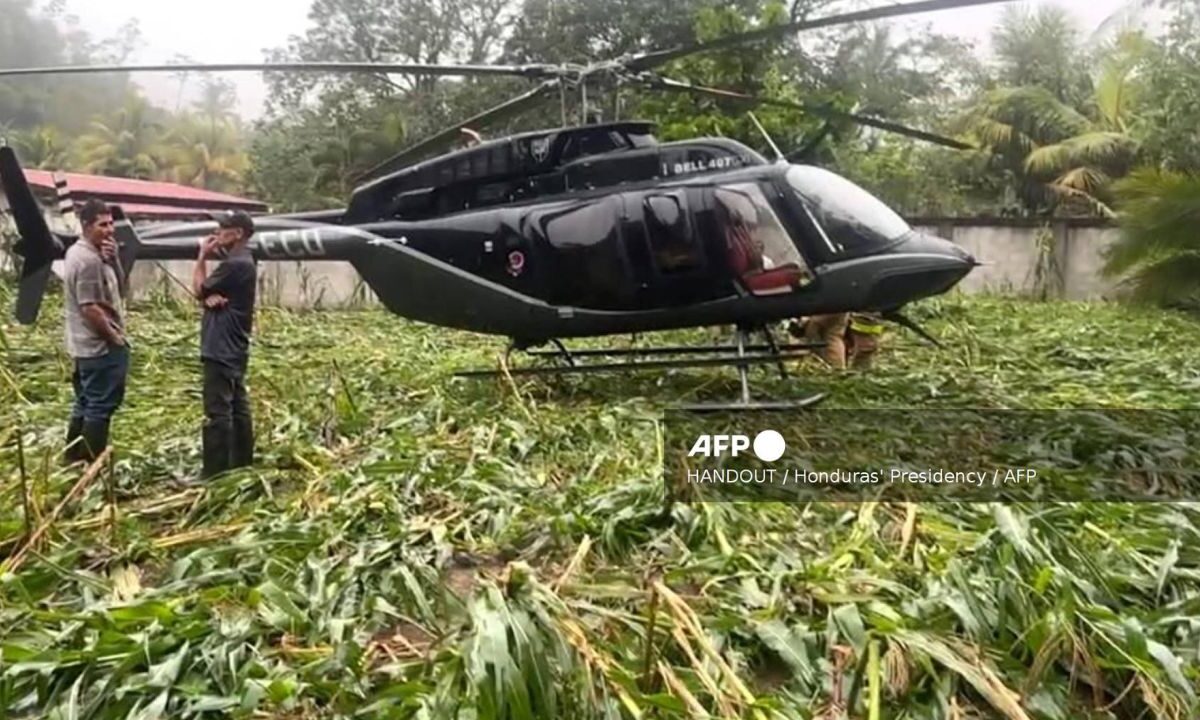 Campesinos de pie junto al helicóptero en el que viajaba la presidenta de Honduras, Xiomara Castro