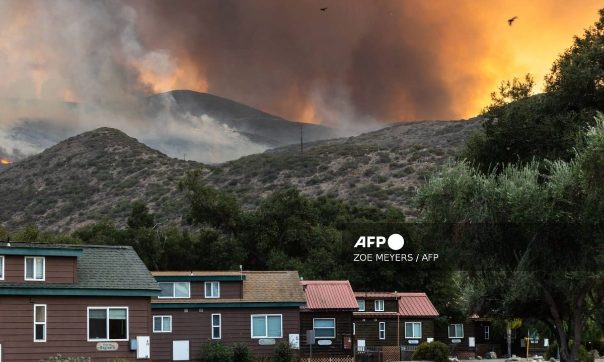 El humo y las llamas del incendio fronterizo se ven en el desierto de Otay Mountain, sobre el campamento Pio Pico en Jamul, condado de San Diego, California