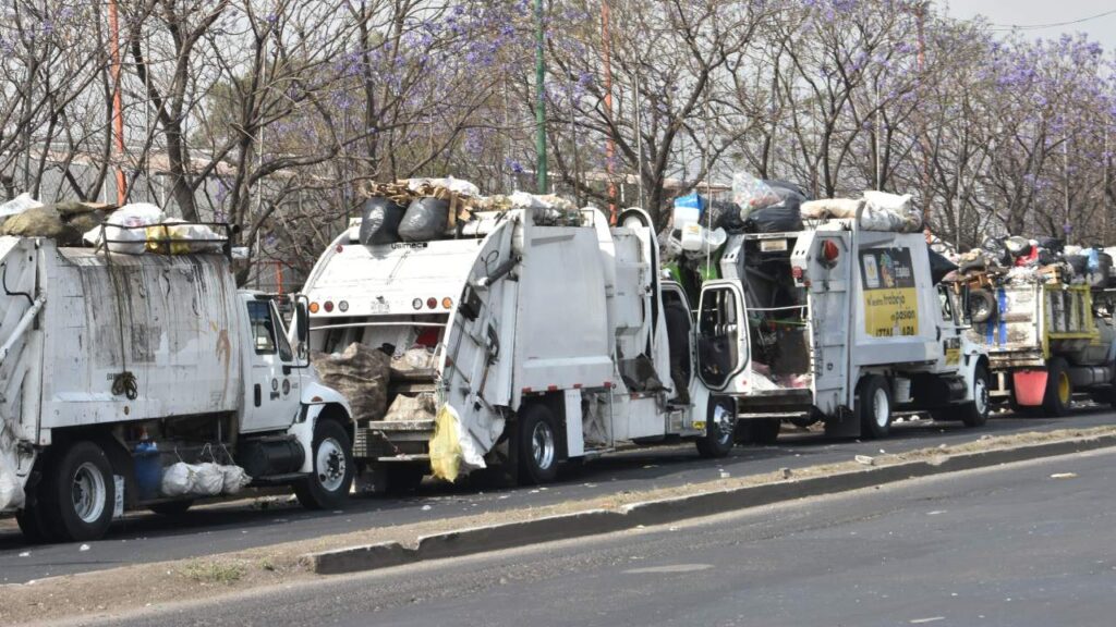 Camiones de basura formados en fila en espera de dejar los residuos recolectados.