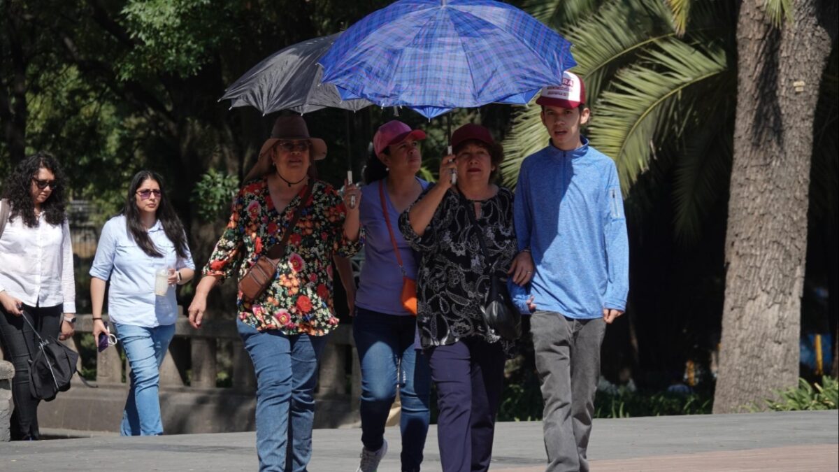 Personas con sombrilla cubriéndose del calor