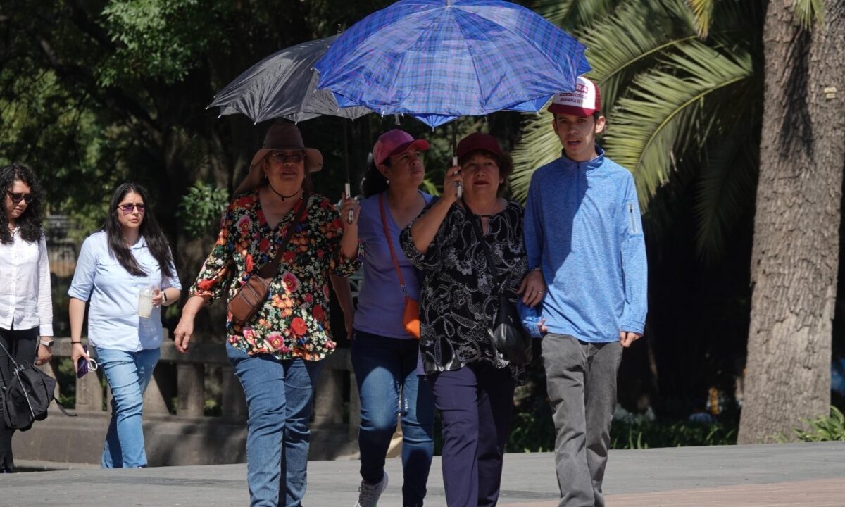 Personas con sombrilla cubriéndose del calor