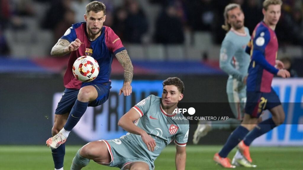 Jugadores de Barcelona y Atlético de Madrid pelean un balón.