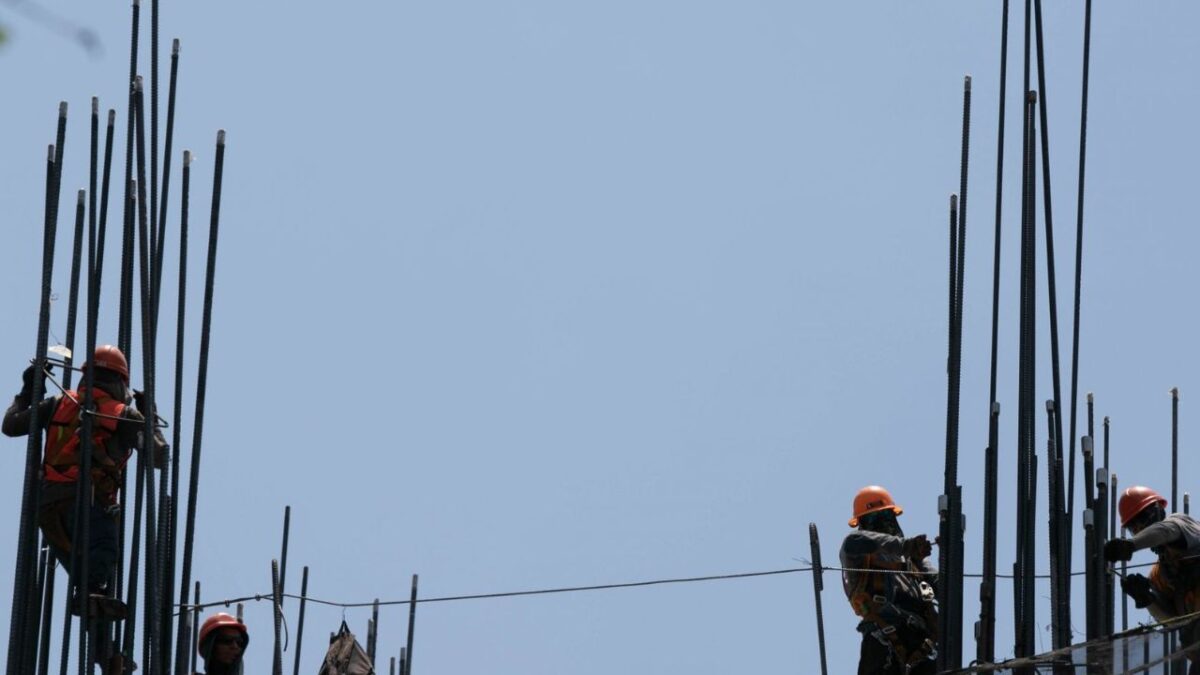 Trabajadores de la construcción trabajan bajo los intensos rayos del sol en avenida Juárez.