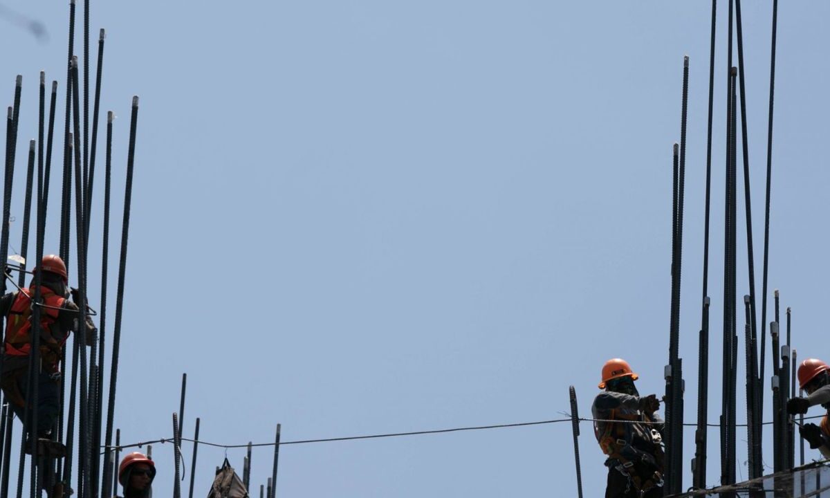 Trabajadores de la construcción trabajan bajo los intensos rayos del sol en avenida Juárez.