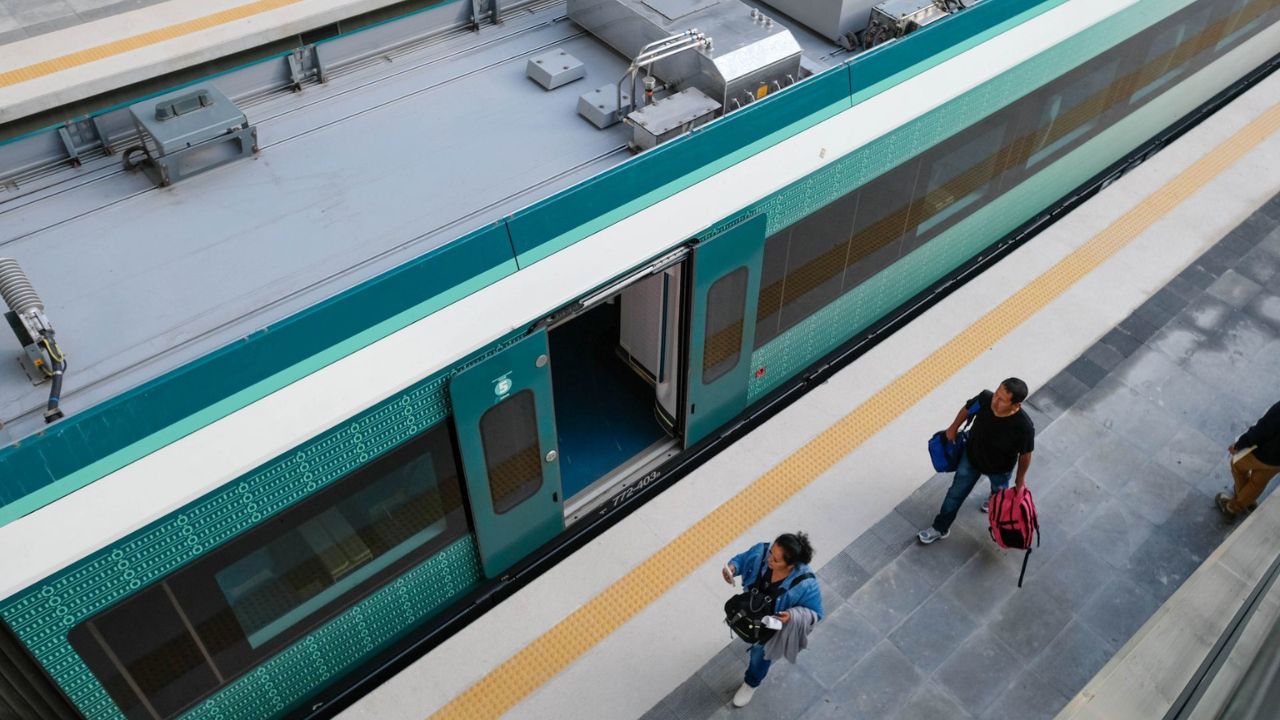 Pasajeros caminando junto a un vagón del Tren Maya 