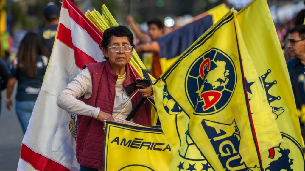 Una comerciante pone a la venta banderas del América y de las Chivas.