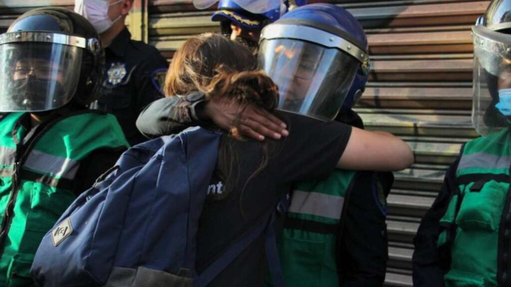 Una mujer policía recibe el abrazo de una participante en una Marcha del 8M.