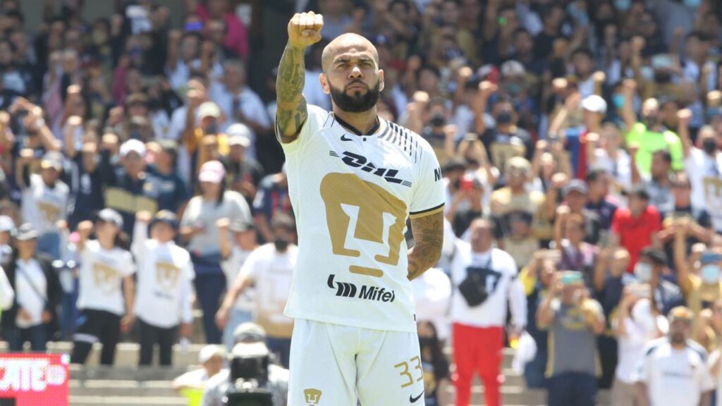 Dani Alves alza el puño mientras entona el himno de la UNAM antes de un partido de los Pumas.