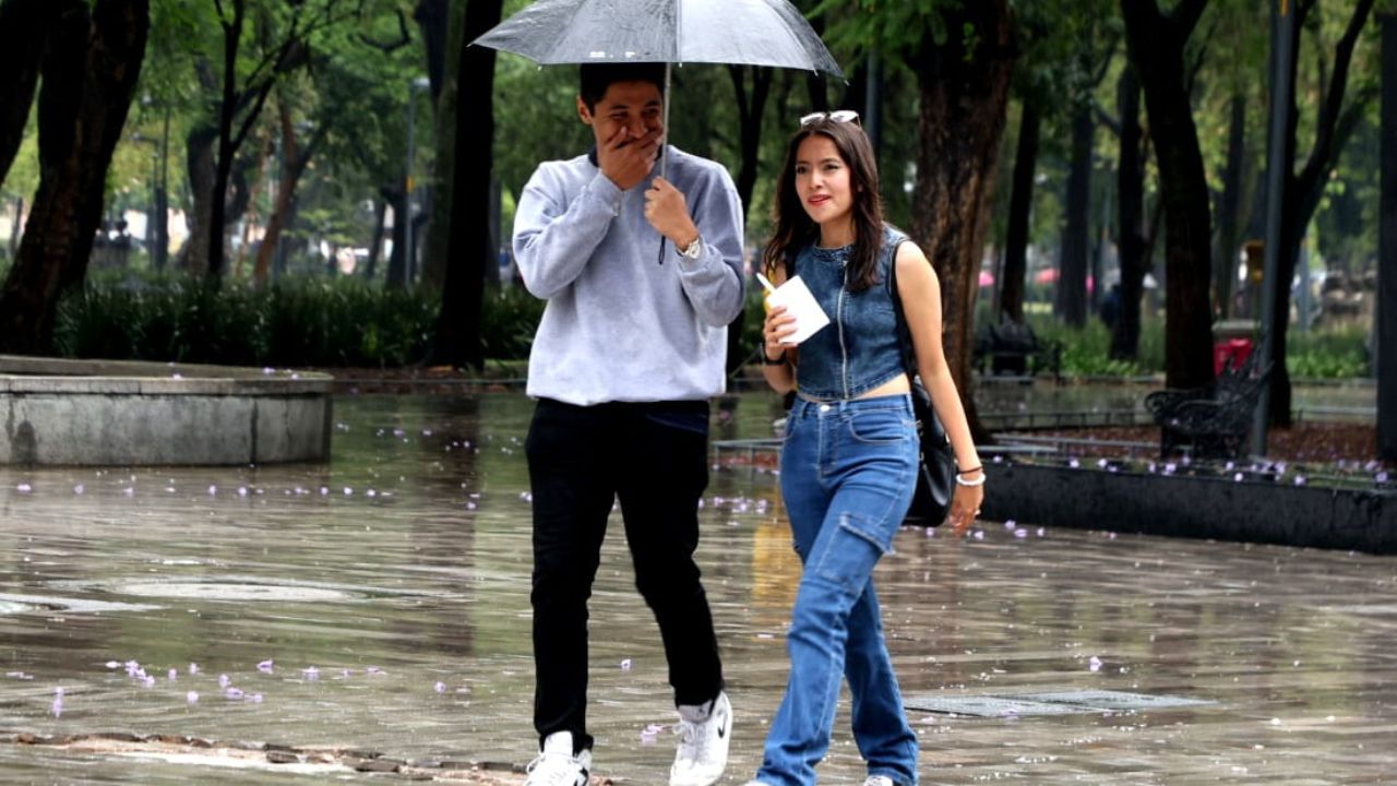 Capitalinos se cubren de la lluvia 
