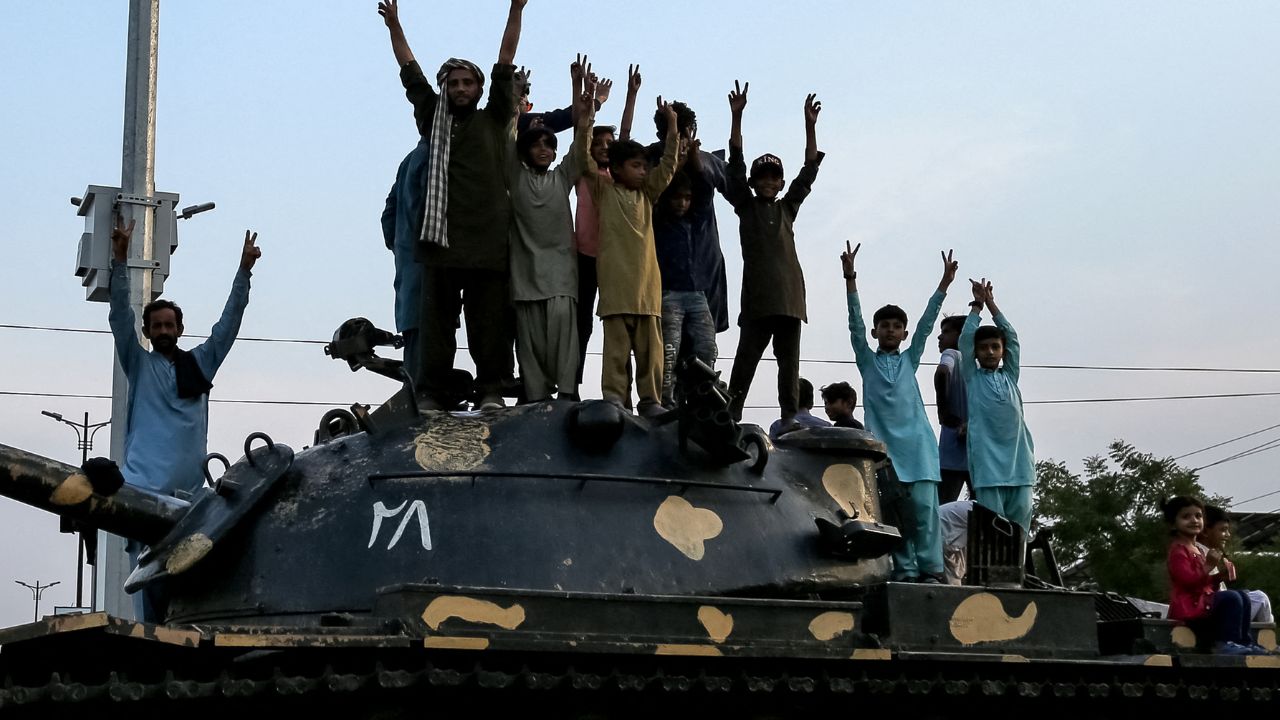 Los pakistaníes, con el símbolo de la victoria, celebran junto a un tanque el alto el fuego entre Pakistán e India