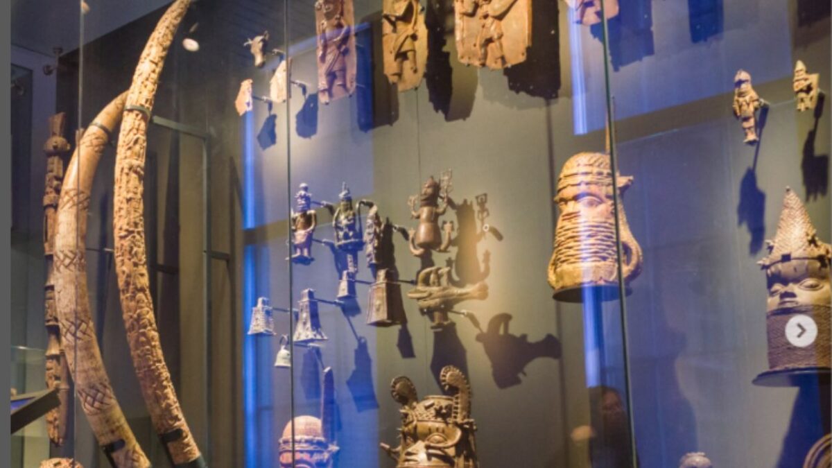 Un empleado de un museo en Países Bajos descuelga cuidadosamente una escultura de bronce saqueada en Nigeria hace más de 120 años.