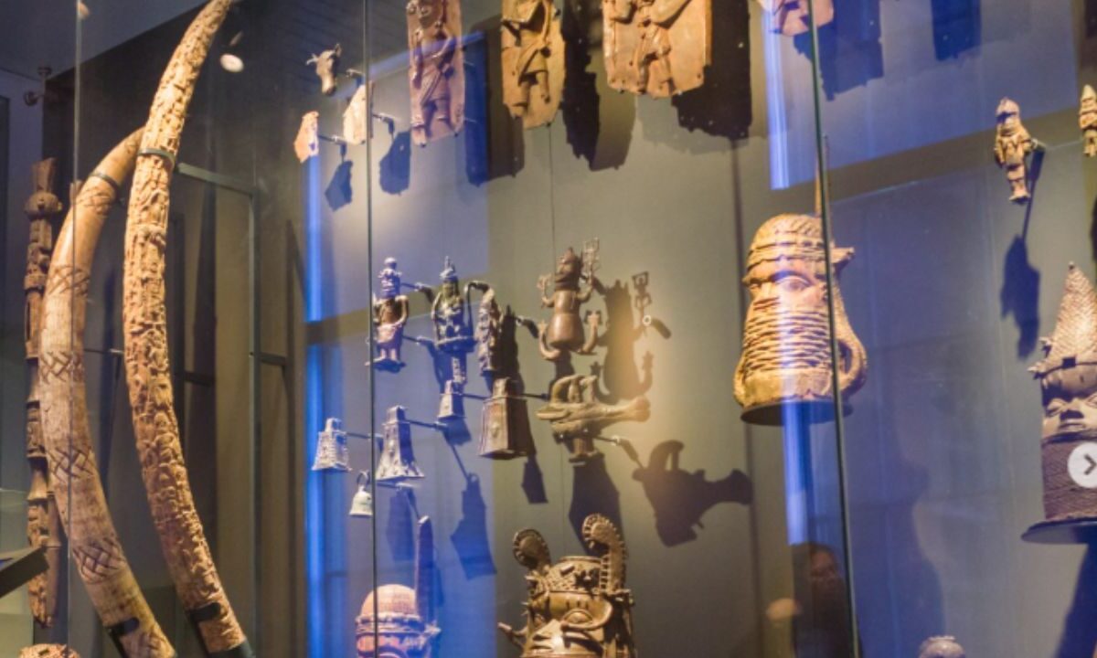 Un empleado de un museo en Países Bajos descuelga cuidadosamente una escultura de bronce saqueada en Nigeria hace más de 120 años.