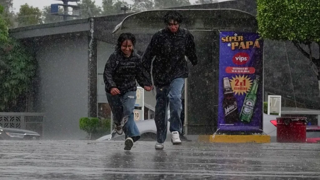 Una pareja corre tomada de la mano, bajo la intensa lluvia que cayó en la ciudad