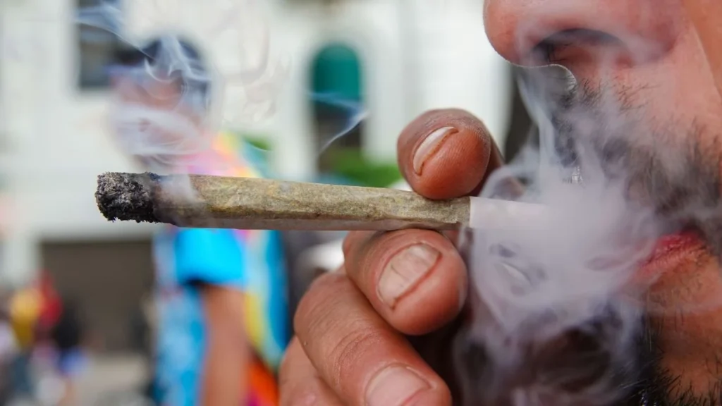 Un hombre fuma cannabis en un porro durante la manifestación por