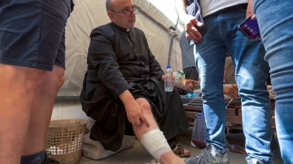El párroco de la iglesia de la Sagrada Familia en la ciudad de Gaza, el padre Gabriel Romanelli, recibe atención médica tras resultar herido en un ataque israelí contra la iglesia